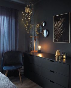 a bedroom with black furniture and lights on the wall