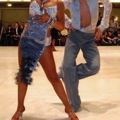 a man and woman are dancing on the runway