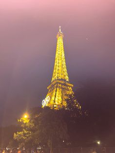 the eiffel tower is lit up at night