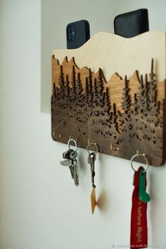 a wooden key holder with two keys hanging from it