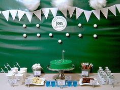 a table topped with a green cake covered in white frosting next to cupcakes