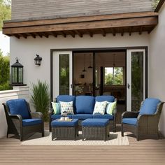 an outdoor living room with blue cushions and furniture