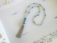 Tassel Necklace handmade by Ralston Originals. This blue tassel necklace is made with a very unique blue bead, with crystals, and silver accents. The necklace is also made with a large sparkling blue crystal bead, and a large silver metal bead. The tassel is made with silver metal Silver Bohemian Lariat Tassel Necklace, Handmade Silver Long Tassel Necklace, Bohemian Silver Tassel Necklace Gift, Silver Bohemian Tassel Necklace As Gift, Adjustable Silver Bohemian Tassel Necklace, Bohemian Silver Adjustable Tassel Necklace, Bohemian Adjustable Silver Tassel Necklace, Silver Bohemian Tassel Necklace, Silver Bohemian Dangle Tassel Necklace