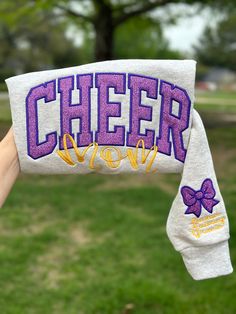 Get cozy and comfortable while showing off your cheer mom pride with this stylish Cheer Mom Sweater. Designed with a cute bow on the sleeve and the option to personalize it with your child's name, this sweater is perfect for cheering on your little one at their next big event. Add a touch of style to your wardrobe and show your support - grab your Cheer Mom Sweater today! Loose-Fitting: Provides maximum comfort and movement during cheer practice or competitions. Long Sleeve: Keeps you warm durin Cheer Embroidery Design, Cheer Mom Sweatshirt Ideas, Customizable Long Sleeve Cheerleading Sweatshirt, Customizable Cotton Cheerleading Sweatshirt, Customizable Cotton Sweatshirt For Cheerleading, Cheer Mom Outfit Ideas, Cheer Mom Shirt, Cheer Mom Outfit, Cheer Coach Outfit