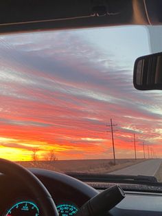 the sun is setting over an empty road