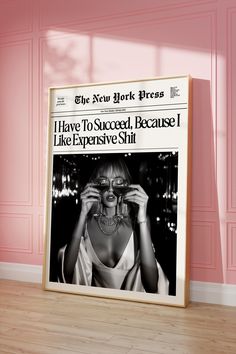 a woman is looking through her glasses while standing in front of a pink wall with an advertisement for the new york times