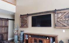 Special walnut Wall-mounted TV concealed with the wooden barn doors from the TV Hide package Barn Door Shutters, Outdoor Tv Cabinet, Outdoor Tv Covers, Bar Tv, Barn Door Cabinet, Barn Door Installation, Sliding Shutters, Hidden Tv, Tv Covers