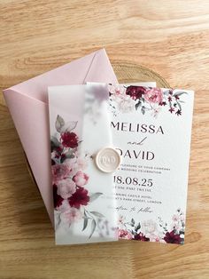 a wedding card with a wax stamp on it sitting on top of a wooden table