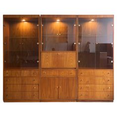 a wooden cabinet with glass doors and drawers