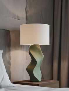 a lamp on a nightstand next to a bed