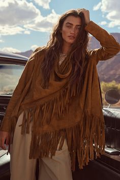 Bold and beautiful, the Trisha wrap jacket boasts 7" of fringe along its hem for movement and western-inspired style. Crafted from soft, supple goatskin suede leather, it can be worn two ways, both equally stunning: open, with the sides cascading down; or wrapped, with one side secured at the shoulder with a corozo button closure. Either way, you'll be the picture of rustic elegance. Featuring lined sleeves for comfortable wear. Wrap is 31 3/4" long plus 7" of fringe along hem. Bohemian Fringe Outerwear For Fall, Fringe Outerwear For Fall Festival, Fall Festival Leather Jacket, Chic Fringe Outerwear For Festivals, Chic Festival Outerwear With Fringe, Fall Leather Jacket With Fringe For Rodeo, Long Sleeve Leather Jacket For Fall Festivals, Fall Festival Long Sleeve Leather Jacket, Leather Jacket With Fringe For Rodeo In Fall