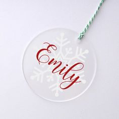 a glass ornament with the word enjoy written in red and white on it