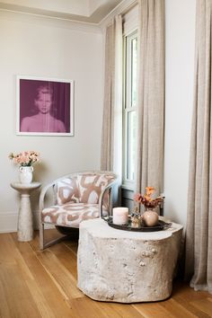 a living room filled with furniture and a painting hanging on the wall next to a window