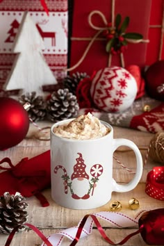 a cup of hot chocolate with whipped cream and christmas decorations