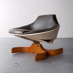 an old chair sitting on top of a wooden stand in the middle of a room