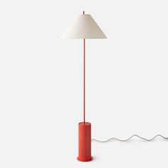 a red lamp sitting on top of a white floor