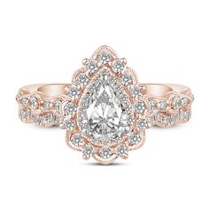 a rose gold engagement ring with a pear shaped diamond in the center and side stones