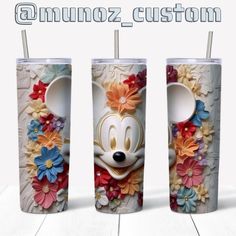 three tumbles with mickey mouse's face and flowers on them, all decorated in different colors