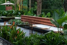 an outdoor seating area surrounded by plants and trees