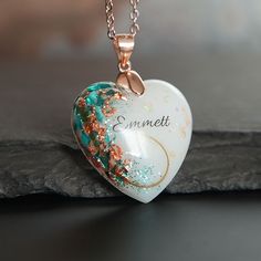 a heart shaped necklace with the word emmet written on it