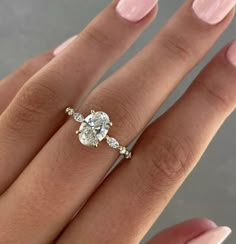 a woman's hand with a diamond ring on her finger and two diamonds in the middle