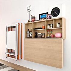 a room with a shelf that has various items on it and a clock mounted to the wall