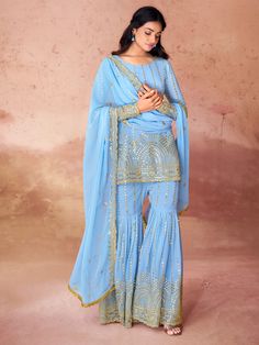 This gorgeous set includes a sky-blue color georgette suit with intricate embroidery and sequin work, a matching georgette sharara with the same delicate detailing, and a dupatta adorned with embroidered sequin work, and designer lace work. The sharara suit comes fully stitched and is available in XS to XXL sizes, ensuring a perfect fit for everyone.
This sky-blue sharara suit is endless. Not only does it offer a stunning and unique look, but you can also wear it to festivals, functions, and eve Blue Chinon Palazzo Set For Diwali, Diwali Blue Chinon Palazzo Set, Blue Georgette Palazzo Set With Mirror Work, Blue Sharara With Gota Work In Chinon, Bollywood Style Light Blue Sharara, Light Blue Chikankari Embroidered Sharara For Wedding, Fitted Light Blue Sharara With Resham Embroidery, Festive Light Blue Sets With Mirror Work, Festive Light Blue Set With Mirror Work