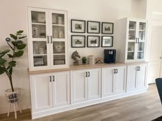 a dining room with white cabinets and pictures on the wall