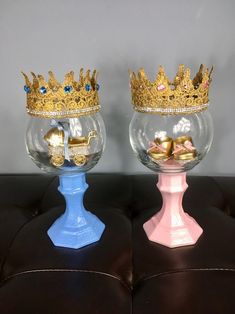 two glass vases with gold crowns on them