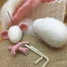 the needle is hooked up to the wool ball and mouse's head next to it