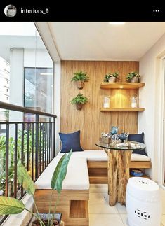 a small balcony with plants and potted plants on the wall, along with a bench that has built - in shelves