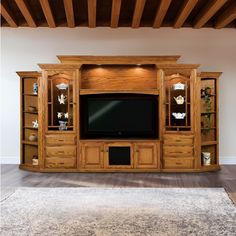 a large entertainment center with wooden cabinets and shelves