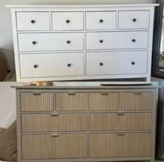 a white dresser sitting on top of a bed next to a mirror