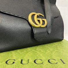 Le sac Gucci Marmont en cuir grainé noir est un accessoire de luxe distinctif. Ce dernier est doté d'une bandoulière en cuir noir, ajustable et amovible. L'intérieur est spacieux et bien organisé. Ce sac est à la fois élégant et fonctionnel, ajoutant une touche sophistiquée à toute tenue. • État : B - Très bon • Dimensions : 32.5x21x14cm • Matière : Cuir grainé • Couleur : Noir • Vendu avec : Dust Modern Shoulder Bag With Cc Turnlock For Business, Modern Business Shoulder Bag With Cc Turnlock Closure, Business Shoulder Bag With Pebbled Leather And Branded Hardware, Business Shoulder Bag With Branded Hardware In Pebbled Leather, Business Shoulder Bag With Branded Hardware And Pebbled Leather, Black Pebbled Leather Satchel For Office, Leather Shoulder Bag With Cc Turnlock And Top Handle, Designer Shoulder Bag With Cc Turnlock For Business, High-end Black Soft Leather Shoulder Bag