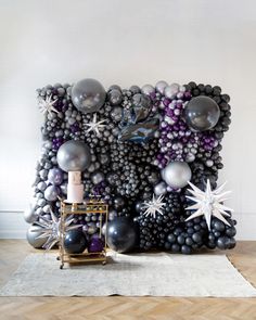 a large balloon wall with silver and black balloons