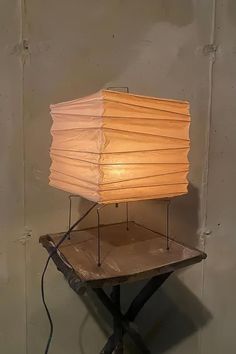 a lamp sitting on top of a table with a wooden base and light bulb attached to it