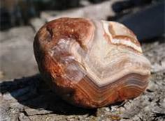 a rock sitting on top of a dirt ground