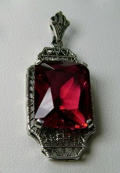 "Simulated Red Ruby Pendant Lantern Design#P13 Custom Made About 6 months ago I found a lovely Art Deco brooch and fell in love with the design. Fashioned in the design of the brooch, I now offer this lovely Antique reproduction pendant in sterling silver (matching 18ct earrings also available for sale). The flawless Simulated 9ct red/pink ruby is 15mm long (just over 9/16\") and 12mm in width (1/2th\"). The pendant is 1 3/8th inches long, it is 9/16th\" wide. The bail opening is 3.5mm wide and Classic Red Ruby Jewelry, Classic Evening Ruby Jewelry, Classic Red Gemstone Jewelry, Victorian Ruby Necklace For Formal Occasions, Red Victorian Necklace For Anniversary, Classic Red Jewelry As A Gift, Classic Red Pendant Necklace, Red Hallmarked Jewelry For Party, Classic Ruby Necklaces For Formal Occasions