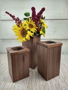 three square wooden vases with flowers in them