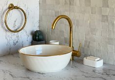 a white bowl sink sitting on top of a counter next to a faucet