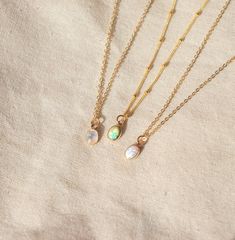 Our Dainty gemstone necklace features a tiny little stone, choose between opal, moonstone and turquoise. DETAILSGOLD VERSION:•PENDANT is Genuine Turquoise, Genuine Moonstone, or Synthetic Opal, measuring 5 x 7mm•CHAIN is 14k Gold Filled•CLASP is 14k Gold Filled Matching ………………………………….PERSONALIZE IT! ADD A STAR INITIAL CHARM:https://www.etsy.com/ca/listing/627638174/add-a-star-initial-charmADD A STAMPED INITIAL:https://www.etsy.com/ca/listing/561708083/add-an-initialADD A BIRTHSTONE:https://www.e Delicate Opal Gemstone Jewelry, Dainty Everyday Necklaces With Natural Stones, Dainty Opal Birthstone Necklaces, Everyday Opal Jewelry With Gemstones, Everyday Opal Gemstone Jewelry, Dainty Opal Round Pendant Necklace, Dainty Adjustable Moonstone Necklace, Delicate Opal Jewelry With Birthstone, Delicate Opal Birthstone Jewelry