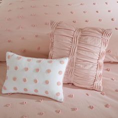 pink and white bedding with polka dot pillows