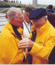 two men in yellow jackets are talking to each other