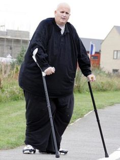 an older man in black is riding on a skateboard