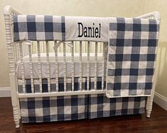 a baby crib with a blue and white checkered blanket