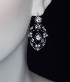 Circa 1910 A pair of silver topped 14K gold earrings features 4 bright white (G color, VS1-SI1 clarity) old cushion cut diamonds (approximately 0.67 ct, 0.68 ct, 0.61 ct, 0.50 ct.) set in buttercup settings. The ornate floral design frames are embellished with 34 old mine cut diamonds. Estimated total diamond weight 3.14 ct Total length with ear wire 40 mm (1 3/8 in.) Width 20 mm (3/4 in) Marked with later Soviet control marks from the 1930s for 583 gold and 875 silver. Georgian Jewelry, Faberge Eggs, Handmade Earring, Silver Tops, Cushion Cut Diamonds, Etsy Earrings Dangle, Earrings Vintage, Rose Cut Diamond, High Quality Jewelry