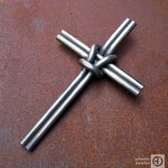 a cross made out of metal sticks sitting on top of a table