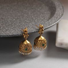 These antique earrings feature a simple jhumki design. Antique gold-tone plated earrings, crafted with peacock motif stud, are attached to the jhumki-shaped filigree design . Ideal for simple occasions and for young girls. Details & Specifications: Materials used: Brass Alloy with Antique Plating Weight - Earrings 16 gm Length - Earrings 4 cm Make it custom Want to make it a custom earring? Sure! Reach out to us at support@tarinika.com and we’ll be happy to make possible modifications at no extr Simple Jhumka, Jhumki Designs Gold, Jumkas Gold, Peacock Motif, Jhumka Designs, Gold Earrings Indian, Peacock Jewelry, Antique Gold Earrings, Choker Necklace Designs