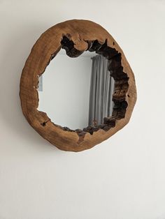 a wooden mirror hanging on the wall