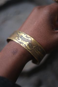 This vintage bracelet with a reptilian motif is unique with etchings one might have found on the walls of a prehistoric cave. Bohemian in mood, the gold-toned  brass piece  will look great layered with other unique jewelry you have collected over the years  condition: it is a little bent. not a real full-curve Adjustable Etched Bronze Bracelets, Symbolic Stamped Cuff Bangle Bracelet, Symbolic Stamped Cuff Bracelet, Antique Finish Adjustable Cuff Bracelet, Bronze Engraved Brass Bracelets, Engraved Bronze Brass Bracelets, Engraved Brass Bangle Cuff Bracelet, Engraved Bronze Bangle Bracelet, Adjustable Bracelet With Antique Finish